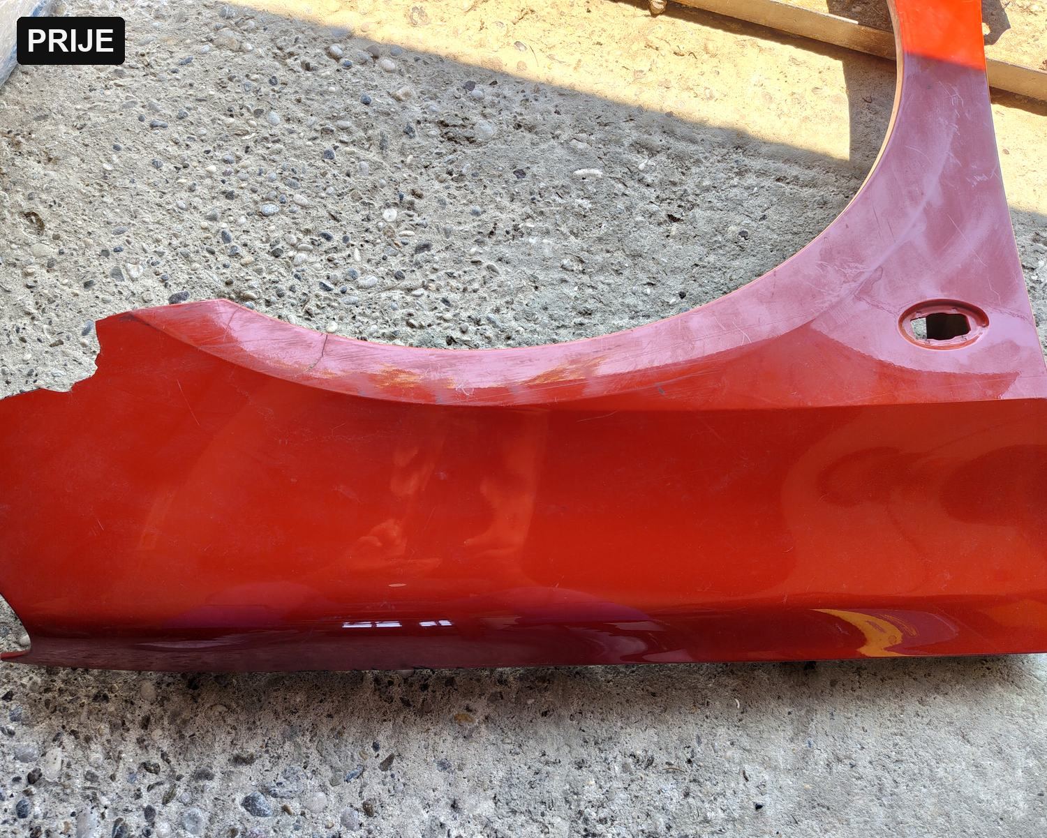 Before: red-painted car fender prior to laser paint stripping — EKO HVOK
